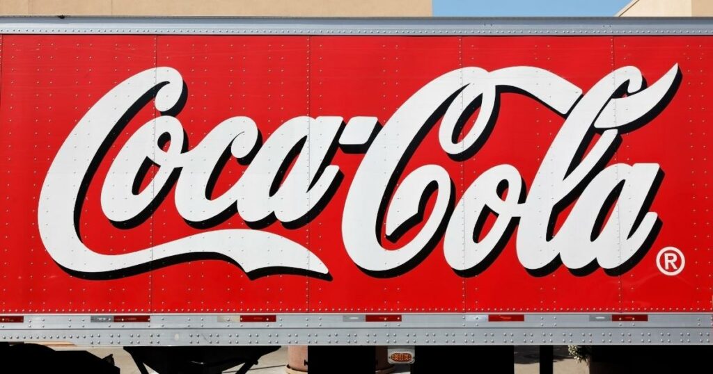 the coca cola signature logo painted in a truck with red background