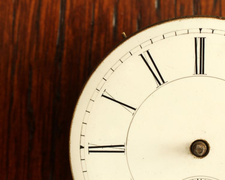 A photo of a quarter part of a classic clock with a wooden background.
