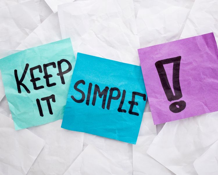 Three sticky notes, green, blue, and violet, each have the words "keep it," "simple," and an exclamation point written on it.