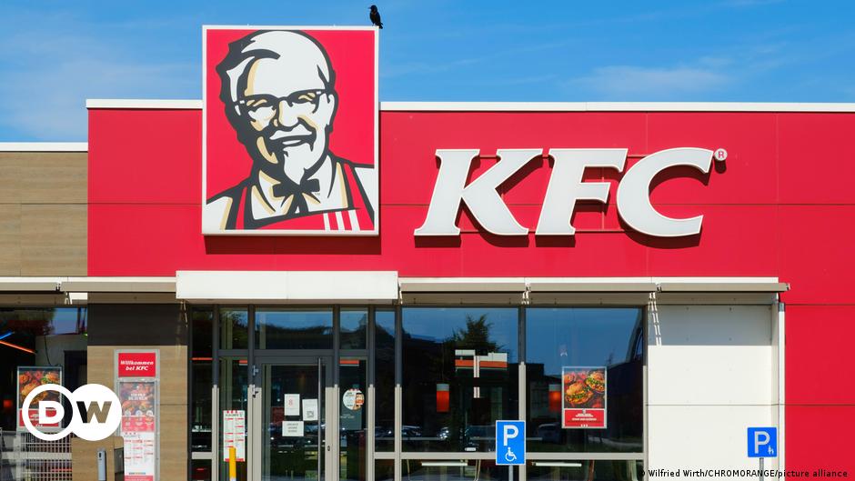 A branch of KFC or Kentucky Fried Chicken fast food chain on a sunny day with a black bird on top.