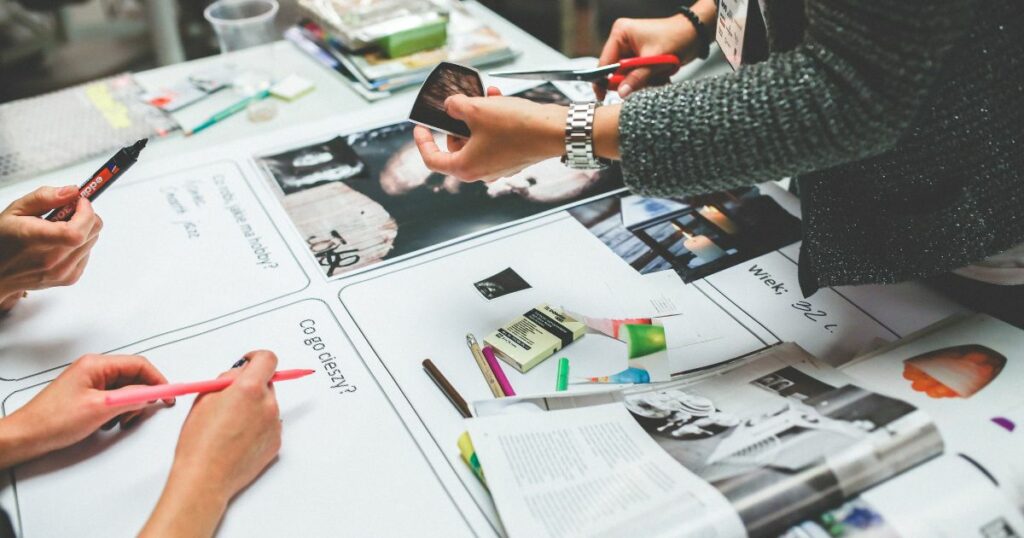 a team working together, cutting papers and doing some random stuff with paper works on the table