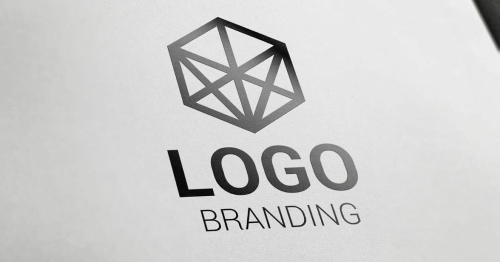 Logo branding text with a hexagon logo design printed on a piece of paper.
