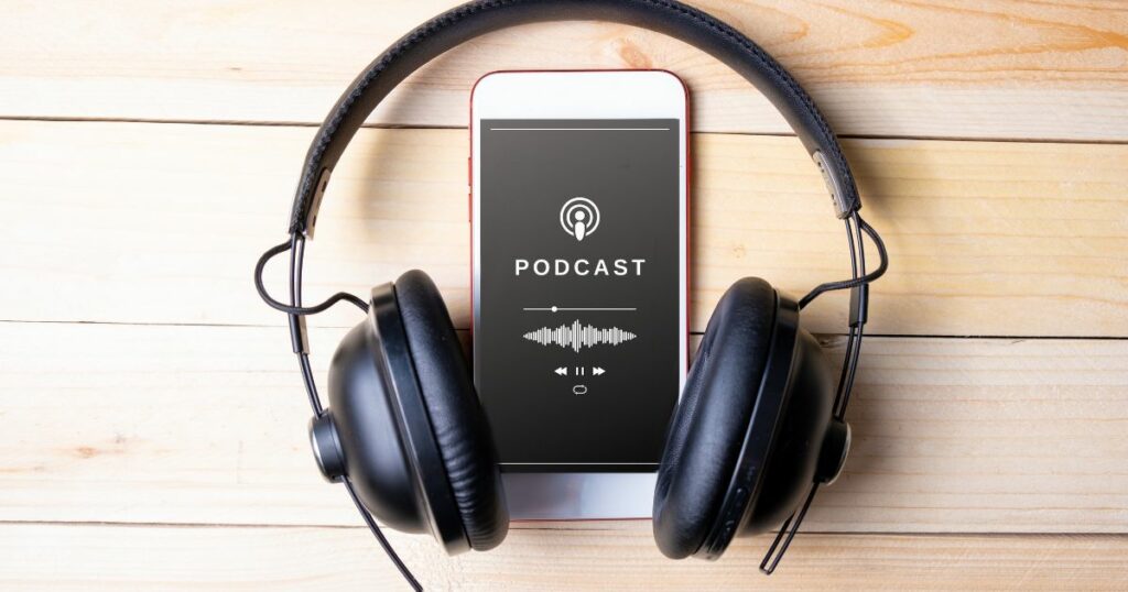 A red and white iphone below a black headphone has a podcast display on its screen.