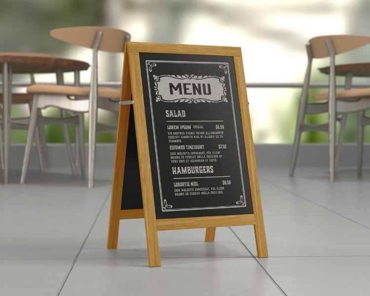 An illustration of a sample black-and-white storefront menu with wooden borders and wooden and steel chairs and tables at the back - one of the marketing materials