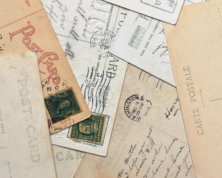 A pile of various collected old postcards with different colors and stamps.