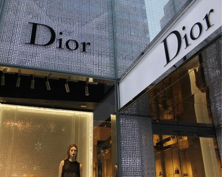 Two logo design signage of the French luxury fashion brand Dior outside its boutique.