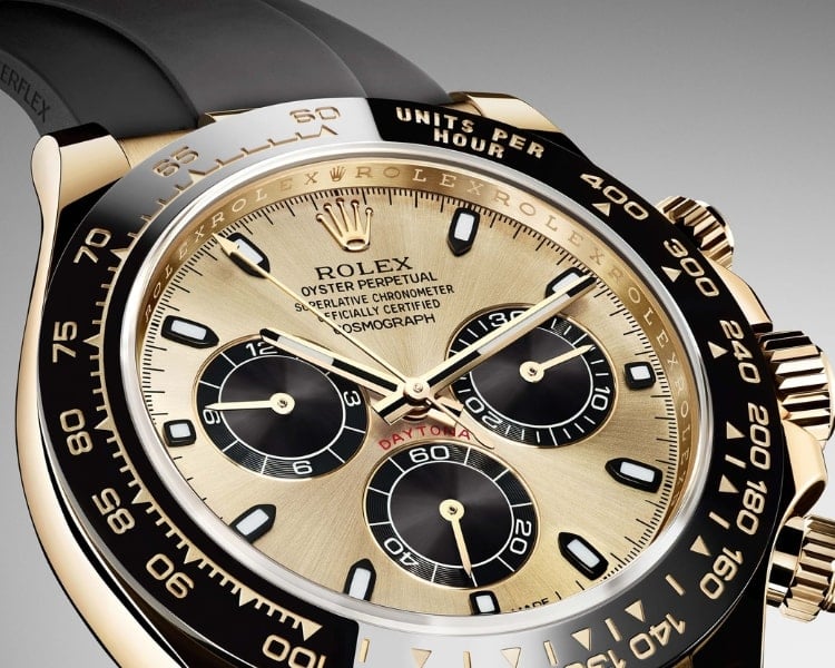 A close-up photo of a gold and black Daytona chronograph watch of the luxury watch brand Rolex.