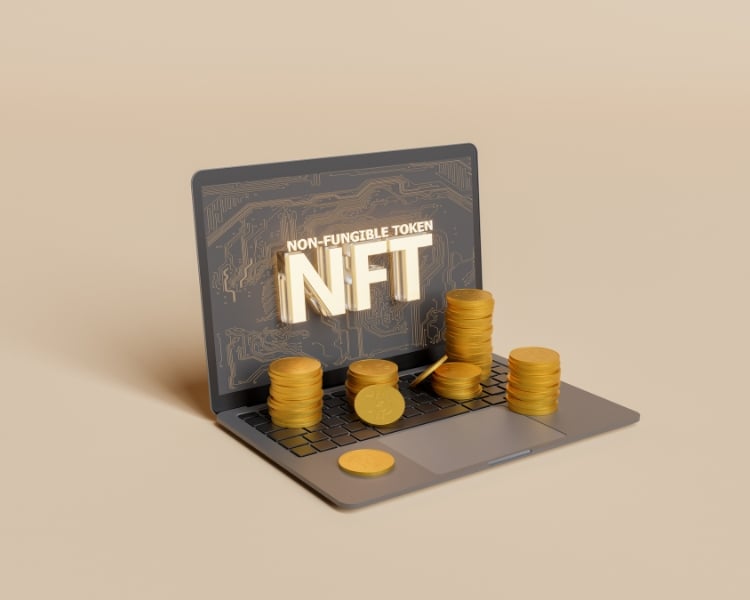 nft font written in a laptop screen with digitalize coins placed in the keyboard