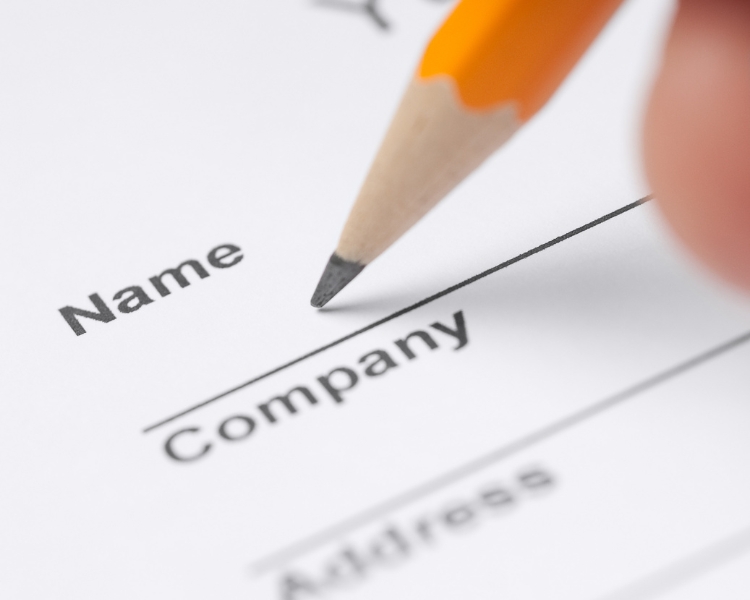 writing on a piece of paper on label form for name, company, and address using an orange pencil