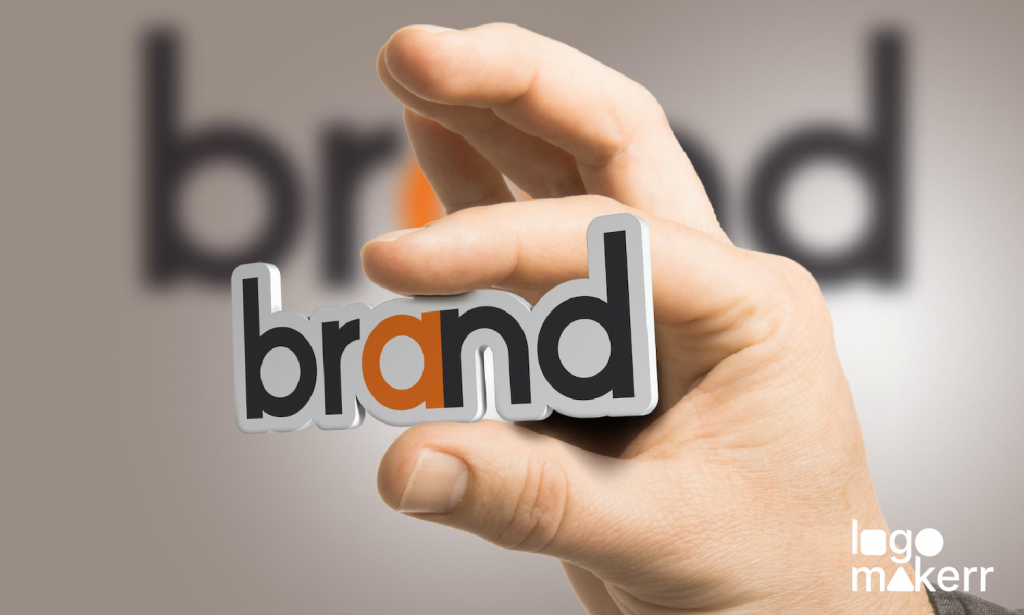 a man's hand holding an object with the word "brand" with his fingers