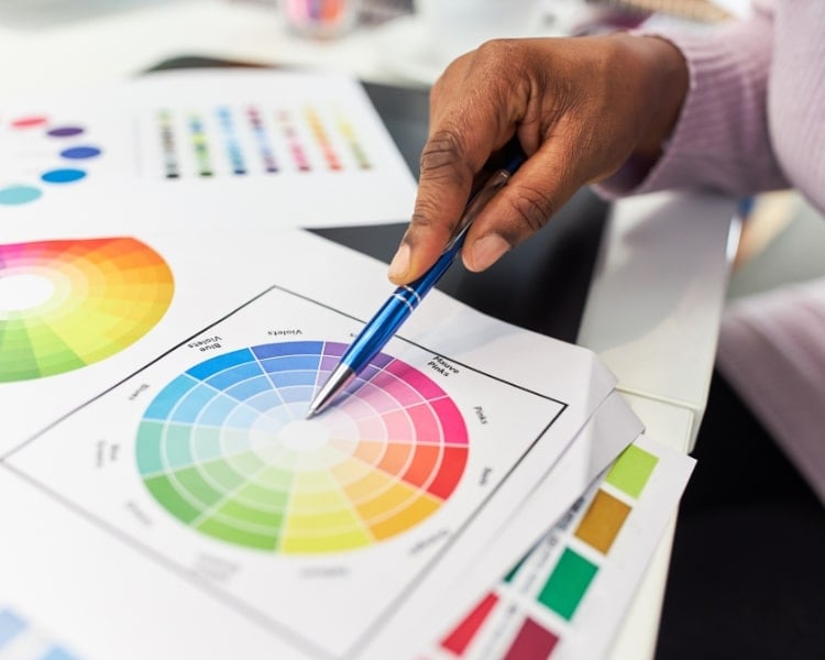 color wheel shown in a white paper with a person pointing pen in it