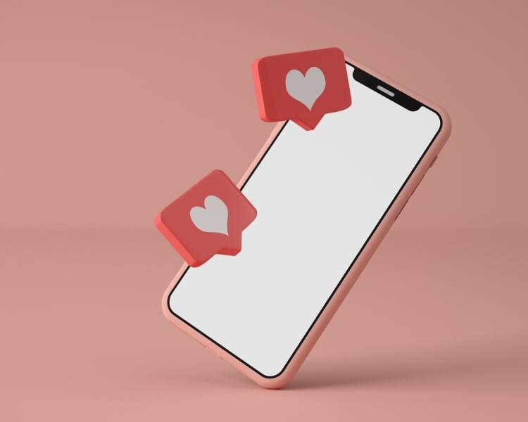 A phone on a pink background showcases an illustration of a heart engagement displayed on its white screen.