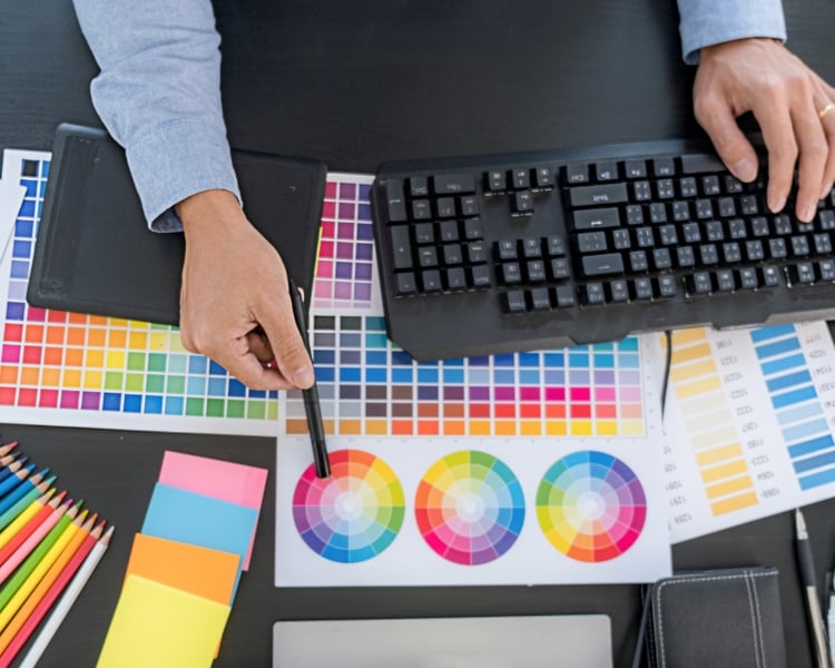 aerial view of hands of a graphic designer choosing color scheme