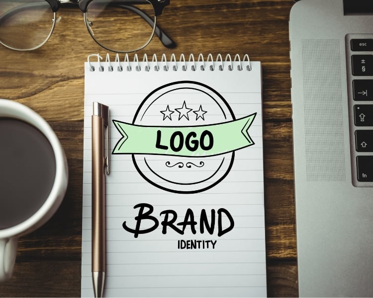 logo and brand written on a notebook with a mug and laptop on the side