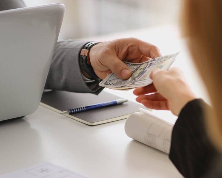 two people lending cash money to another person, probably after a transaction