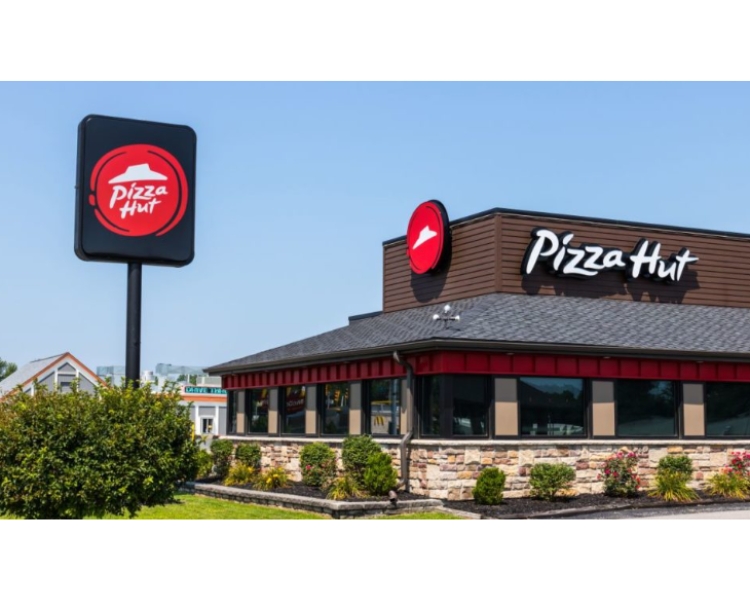 a pizza hut restaurant photo taken outside with logo design on the tall, long stand and with the restaurant