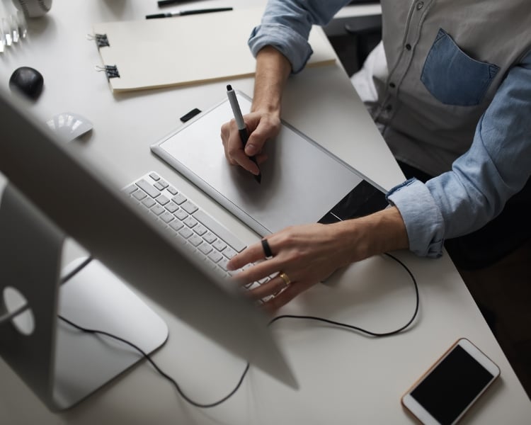 aerial view of what graphic designer does in front of monitor and within its table